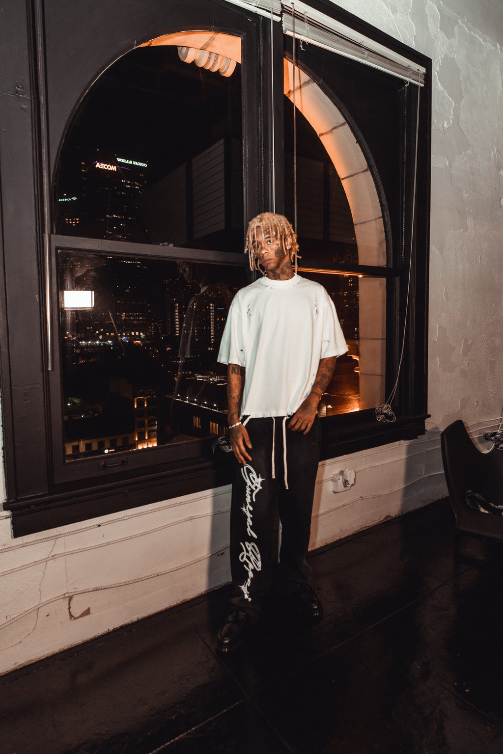 Washed Logo Sweatpants - washed black sweatpants with long cream drawstrings and white gothic 'Funeral Apparel' script printed down the right leg, paired with a white distressed short sleeve t-shirt