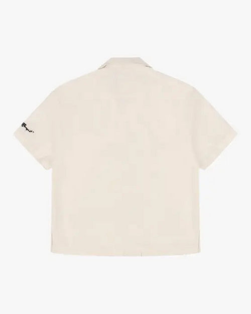 Barbed Wire Pocket Shirt (Ivory), flat product shot of the back of a short-sleeve shirt with black sleeve embroidery.