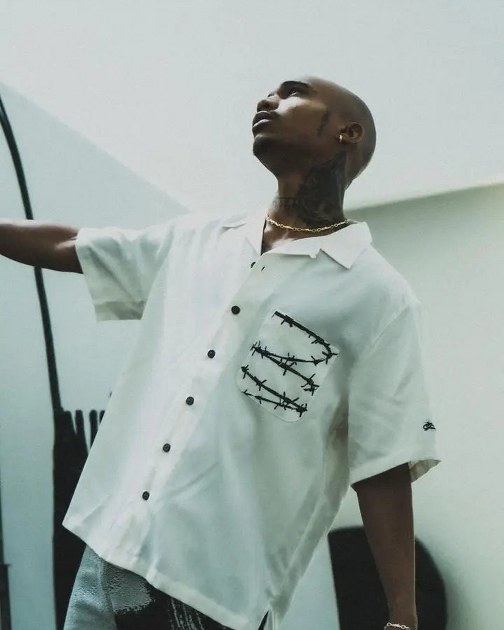 Barbed Wire Pocket Shirt (Ivory), sleeve detail worn by a model, showing a black script logo.